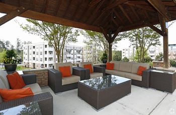 A patio with a table and chairs under a roof.